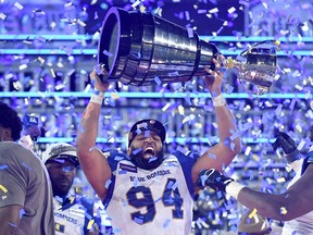 Winnipeg Blue Bombers defensive lineman Jake Thomas (94) lifts the Grey Cup trophy after defeating the Hamilton Tiger-Cats in the 108th championship final at Tim Hortons Field on Sunday, Dec. 12, 2021.