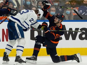 Edmonton Oilers' Leon Draisaitl (29) holds Toronto Maple Leafs' Travis Dermott (23), drawing a penalty, during first period NHL action at Rogers Place in Edmonton, on Tuesday, Dec. 14, 2021. Photo by Ian Kucerak