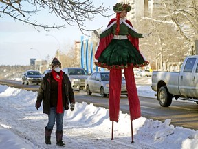 Liz Hobbs, right, dressed as a Christmas fairy, and Marian Brant, left, carefully walk on a snow covered sidewalk on 100 Avenue near Grant Notley Park on Sunday, Dec. 19, 2021, where Edmonton's first Winter Promenade, presented by the Silver Skate Festival Society, was held on Victoria Promenade.
