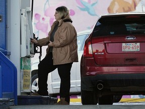 A motorist fills up with gas at a Husky station on 109 Street at 71 Avenue, which was selling gas at 129.90 on Friday Dec. 3, 2021. Gas prices are starting to come down at some stations in the city.