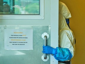 A technician wearing a full body suit enters a biosafety level 3 Covid-19 research laboratory at the African Health Research Institute in Durban, South Africa, on Wednesday, Dec. 15, 2021.