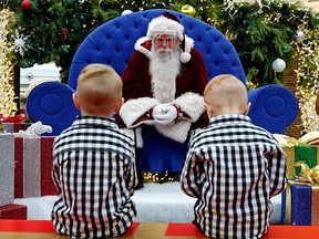 Emery Gartry (4) and brother Soren Gartry (3) had a socially distanced conversation with Santa at Bonnie Doon Centre shopping mall in Edmonton on December 1, 2021, where Santa was observing pandemic protocols. Five minute photo sessions can be booked with Santa by online reservation only until December 24. (PHOTO BY LARRY WONG/POSTMEDIA)