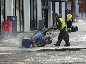 Small chunks of ice fly off the sweepers as crews try to ahead of the ice buildup from the freezing rain in downtown Edmonton, December 8, 2021. Ed Kaiser/Postmedia