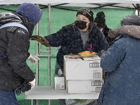 Shanell Twan, with Canadian Association of People Who Use Drugs, hands out hand warmers, warm clothing, drinks, and food during a Drug War Armistice Day Community Outreach event in downtown Edmonton, Thursday Dec. 16, 2021.
