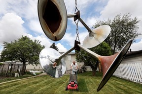 I think I was driving through a back alley while covering a nearby memorial when I spotted this piece of art. Randall (last name not given) is framed by a piece of art hanging in a tree as he mows his backyard in Edmonton’s Rosslyn neighbourhood on June 7, 2021. Randall made the sculpture out of discarded metal stands that once held wallpaper samples.