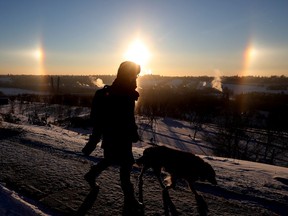 A pedestrian walks past a sundog hanging over Edmonton's river valley, Friday Dec. 17, 2021. An extreme cold warning has been issued for the Edmonton region, with the windchill it felt like -33. Photo by David Bloom