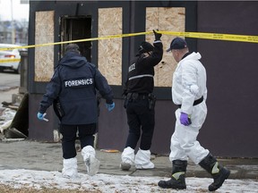 Fire investigators and members of the Edmonton police forensics unit work at the scene of a fire at 106A Avenue and 95 Street in Edmonton on Wednesday, Dec. 1, 2021. After firefighters extinguished an early morning fire in the abandoned building, they discovered the body of a man inside.