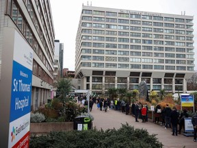 People queue outside a coronavirus disease (COVID-19) vaccination centre at St Thomas's Hospital in London, Britain, December 13, 2021.