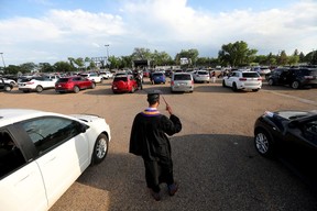 Ethan Robinson, 18, waits for his turn to receive his diploma during Archbishop MacDonald High School’s drive-in graduation ceremony, at the Edmonton Expo Centre parking lot on June 4, 2021. The unorthodox ceremony was in response to COVID-19 health restrictions. Graduates would individually be picked up and ferried to the front of the event where they would receive their diploma before being returned to their vehicle.