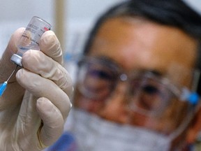 A health worker prepares to administer a booster dose of the Sinovac Biotech Covid-19 vaccine at a Selcare clinic in Shah Alam, Selangor, Malaysia, on Wednesday, Dec. 8, 2021. The new omicron variant prompted Malaysia to pause the transition to the endemic phase of the outbreak until it obtains more data.