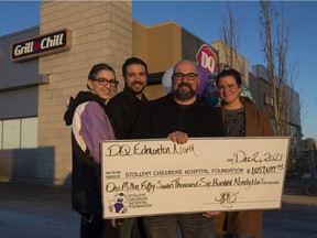 Cassie Fylyshtan, left, Scott Fylyshtan, Marc Cardinal and Michelle Cardinal outside their north Edmonton Dairy Queen franchise after reaching $1 million fundraised in support of the Stollery Children's Hospital in Edmonton on Thursday, Dec. 2, 2021.