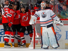 NEWARK, NEW JERSEY - DECEMBER 31: Nico Hischier #13 of the New Jersey Devils celebrates his first period goal against Mike Smith #41 of the Edmonton Oilers with his teammates at Prudential Center on December 31, 2021 in Newark, N.J.