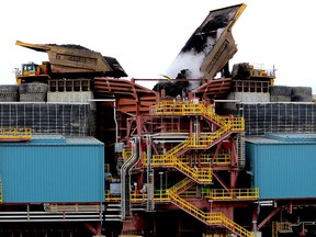 Heavy hauler trucks unload into a crusher at the Fort Hills oilsands project.