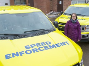 Jessica Lamarre, acting director for traffic safety, with two of the mobile photo radar trucks that received a bright wrap to make them more visible to motorists on Dec. 2, 2019.