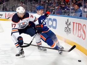 Warren Foegele #37 of the Edmonton Oilers and Jean-Gabriel Pageau #44 of the New York Islanders battle for the puck during the first period at the UBS Arena on January 01, 2022 in Elmont, New York.