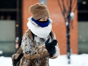 A pedestrian makes their way along Whyte Avenue near 104 Street in Edmonton on Monday, Jan. 3, 2022. Five to 10 cm of snow was expected to fall in Edmonton Monday, with a wind chill near minus 34. Photo by David Bloom