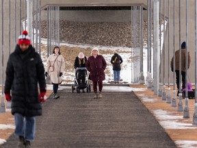 People cross the Tawatinâ Bridge on a snowy morning in Edmonton, on Wednesday, Jan. 26, 2022. The bridge connects the Cloverdale neighbourhood with downtown and was constructed as part of the Valley Line LRT.