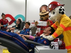STARS flight paramedic Emerson North gets a massage from Edmonton Fire Department mascot "Sparky" while donating blood at the Canadian Blood Services clinic in 2020. This month police, firefighters and paramedics in Edmonton, Calgary, and Red Deer are challenging each other to see who can bring in the most donations, with a goal to collect 5,188 whole blood units and bring in 595 new donors in support of Canadian Blood Services' Canada's Lifeline.