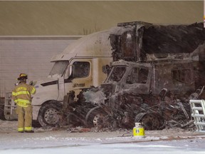 A firefighter inspects a fire in a machine yard at 6891 67 St. on Saturday, Jan. 1, 2022 in Edmonton.