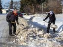 Die Nachbarn Dana Sydor und Nizam Khurshed haben kurz nachdem ein Grader sie am Mittwoch, dem 12. Januar 2022, in Nord-Edmonton erstellt hatte, vor ihren Häusern klare Schwaden abgelegt. 