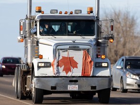A convoy of trucks, cars and pickup trucks is driving east on Highway 16A from Devon, Saturday, January 29, 2022.