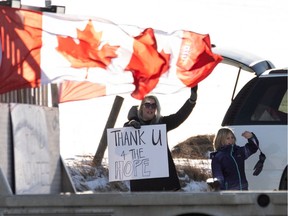 Supporters cheer as a convoy of trucks, cars and pickup trucks head east on Highway 16A from Devon to convoy to the Alberta Legislature in support of the National Freedom Convoy 2022 in Edmonton, Saturday, January 29, 2022. Convoy participants are in opposition to vaccination mandates.