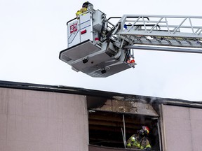 Firefighters inspect a fourth floor apartment fire at Brighton Court apartments at 10525 156 St. on Monday, Jan. 10, 2022 in Edmonton. A woman that lives next to the apartment where the fire occurred said there was an explosion before the fire started.