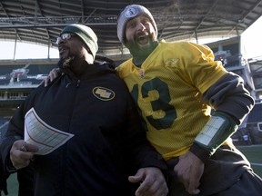 Then-Edmonton Elks quarterback Mike Reilly (13) grabs offensive co-ordinator Stephen McAdoo for a picture, which the coach does not like to have taken, during practice on Nov. 28, 2015, ahead of the 103rd Grey Cup in Winnipeg.