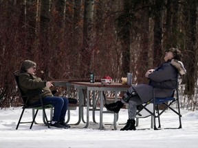 Two socially-distanced women enjoy some conversation with coffee at Hawrelak Park in Edmonton on Friday March 12, 2021. (Photo by Larry Wong/Postmedia)