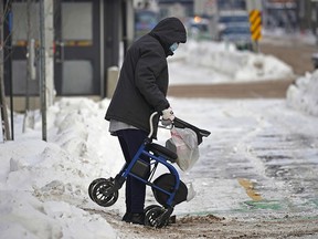 A senior navigates a snow covered street in downtown Edmonton on January 10, 2022.  (PHOTO BY LARRY WONG/POSTMEDIA)