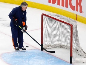 Head coach Dave Tippett clears pucks out of an empty net during an Edmonton Oilers team practice in Edmonton on Thursday, Jan. 13, 2022. Photo by David Bloom