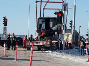 Crews use a crane to unload LRT cars off of a semi trailer in the 75 Street off ramp of Whitemud Drive, in Edmonton on Tuesday, Jan. 18, 2022. Photo by David Bloom