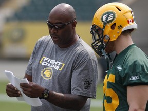 Offensive coordinator Stephen McAdoo speaks with safety Mike Miller (25) during an Edmonton Eskimos practice at Commonwealth Stadium in Edmonton, Alta., on Monday, July 7, 2014.