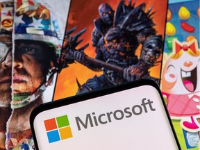 Microsoft logo is seen on a smartphone placed on displayed Activision Blizzard's games characters in this illustration taken January 18, 2022.