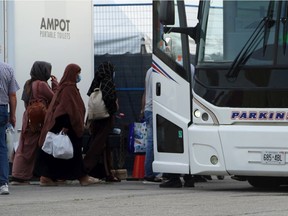 Refugees from Afghanistan board a bus after being processed at Pearson Airport in Toronto on Aug 17, 2021, after arriving indirectly from Afghanistan.