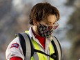 A Canada Post employee wearing cloth mask delivers mail in Edmonton in Dec. 2020.