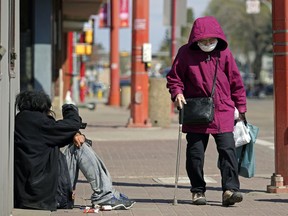 An elderly woman walks on 97 Street in downtown Edmonton's Chinatown district on Monday May 10, 2021.