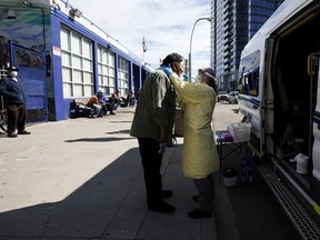 Community paramedic Katrina Petrosky performs COVID-19 nasal swab testing outside Boyle Street Community Services, in downtown Edmonton Wednesday Sept. 9, 2020.