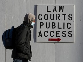 A pedestrian wearing a face mask makes their way past the Law Courts, in Edmonton Thursday Dec. 24, 2020.