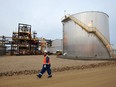 An oilfield worker walks past the Statoil oil sands facility near Conklin, Alberta.