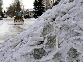 Snow is cleared off a residential street in southwest Edmonton on Wednesday January 12, 2022. (PHOTO BY LARRY WONG/POSTMEDIA)