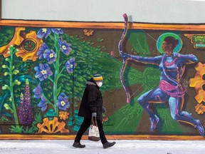 A pedestrian walks past a mural on 118 Avenue on Tuesday, Feb. 1, 2022 .  While colder temperatures have moved into Edmonton, milder weather is expected to return at the end of the week.