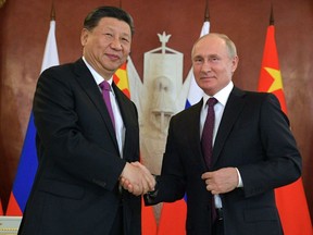Russian President Vladimir Putin and his Chinese counterpart Xi Jinping shake hands after their talks at the Kremlin in Moscow on June 5, 2019
