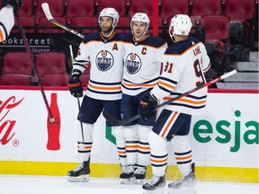 Connor McDavid #97 of the Edmonton Oilers celebrates his first period goal with teammates Darnell Nurse #25 and Evander Kane #91 during their game at the Canadian Tire Centre on January 31, 2022 in Ottawa, Ontario, Canada.