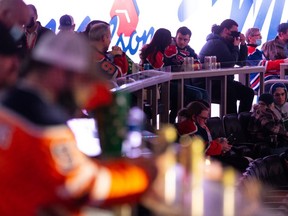 Fans drink beer in the stands after the Alberta government changed COVID-19 rules as the Edmonton Oilers face the Chicago Blackhawks during NHL play at Rogers Place in Edmonton, on Wednesday, Feb. 9, 2022.