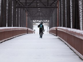 A cross country skier crosses the Ainsworth Dyer Bridge between Gold Bar Park and Rundle Park after exercising in Edmonton, on Wednesday, Feb. 16, 2022.