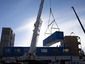 A prefabricated apartment is lifted onto a City of Edmonton supportive housing complex being built at the corner of 93 Street and 82 Avenue.