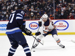 Edmonton Oilers center Connor McDavid (97) skates towards Winnipeg Jets left wing Kyle Connor (81) in the first period at Canada Life Centre on Feb. 19, 2022.