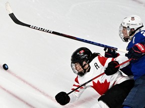 Canada's Jocelyne Larocque and USA's Hilary Knight vie for the puck during the women's preliminary round group A match of the Beijing 2022 Winter Olympic Games ice hockey competition between USA and Canada, at the Wukesong Sports Centre in Beijing on February 8, 2022.