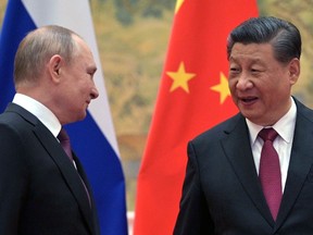 Russian President Vladimir Putin, left, and Chinese President Xi Jinping arrive to pose for a photograph during their meeting in Beijing, on February 4, 2022.